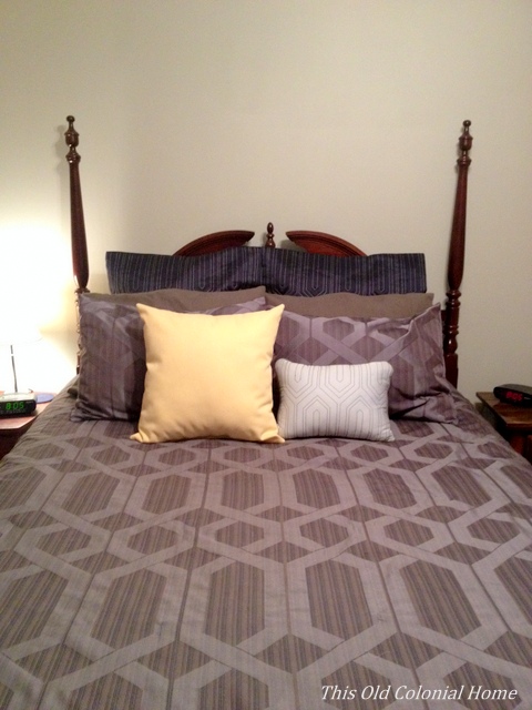 Dark blue bedding with gray walls 