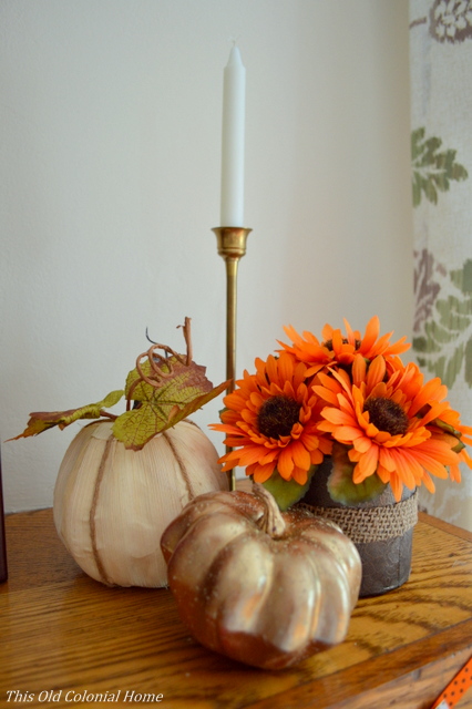 Pumpkins, flowers and candle on mantel 